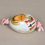 A Russian porcelain egg The front painted with a vignette of the priest Nikona,