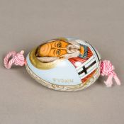 A Russian porcelain egg The front painted with a vignette of the priest Nikona,