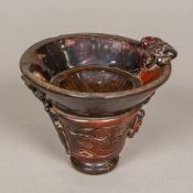 A Chinese carved horn libation cup Of typical form, carved with mythical beasts,