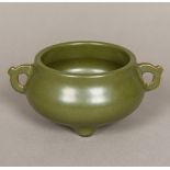 A Chinese porcelain censer Of squat twin handled form with allover green glaze,