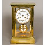 A 19th century lacquered brass cased four glass mantel clock The white enamelled dial with Roman