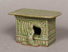 A Chinese celadon ground pottery headrest The florally decorated rounded rectangular top above the
