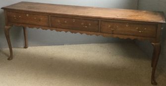 An 18th century oak low dresser The moulded crossbanded rectangular top above three crossbanded