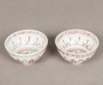 A pair of Chinese porcelain tea bowls Decorated with iron red lotus strapwork. 9 cm diameter.