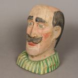 A Folk Art painted carved wooden bust Formed as a moustachioed gentleman with a green stripped top.