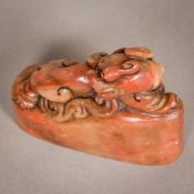 A Chinese carved soapstone seal Formed as a temple lion, the underside with carved matrix.