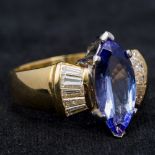 An 18 ct gold tanzanite and diamond ring The central claw set tanzanite flanked by twin rows