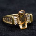 An 18 ct gold diamond and imperial topaz ring With central claw set topaz flanked by baguette cut