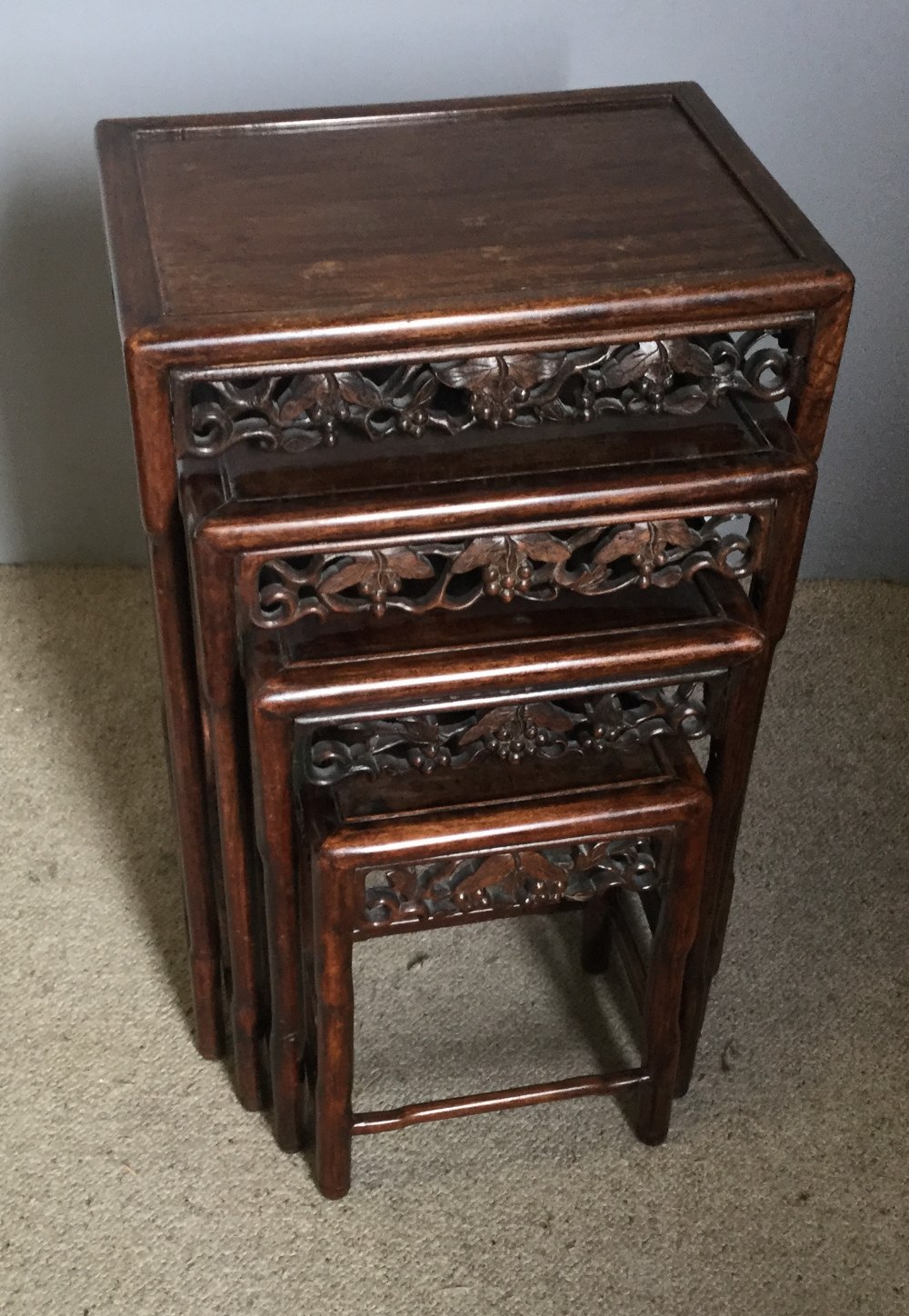A late 19th century Chinese carved hardwood quartetto nest of tables Each rectangular panelled top