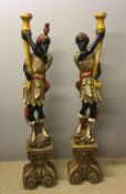 A pair of painted carved wooden Blackamoors Each modelled in typical attire holding a cornucopia,