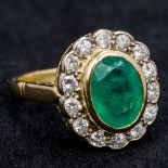 An 18 ct gold diamond and emerald cluster ring The central emerald flanked by a row of diamonds