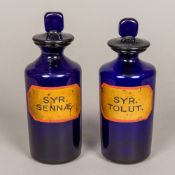 Two late 19th century blue glass apothecary jars and covers Both with gilt painted cartouches