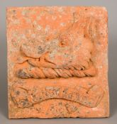 An 18th/19th century terracotta panel Decorated in relief with a boar's head above a scrolling