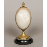 A carved and mounted emu's egg Carved to the front with a vignette of a kookaburra. 21.5 cm high.