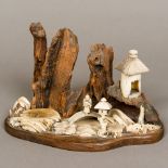 A 19th century Japanese bone, ivory and wooden landscape display Modelled with a figure on a bridge,