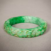A Chinese jade bangle Carved in the round with various fish and mythical beasts. 8 cm diameter.