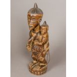 A large African tribal carved wooden figural group Formed as a female figure holding a child on her