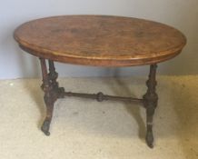 A Victorian inlaid burr walnut centre table The inlaid oval top standing on double turned and