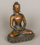 A Tibetan patinated bronze model of Buddha Typically modelled, seated in the lotus position. 26.