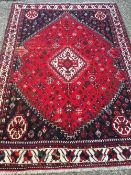 A wool rug The wine red field enclosing a central medallion,