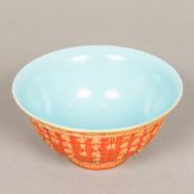 A Chinese porcelain bowl With gilt painted moulded calligraphic decoration on a red ground,