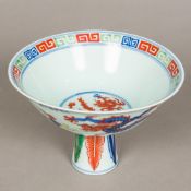 A Chinese Wucai porcelain stem bowl Worked with five-clawed dragons chasing flaming pearls,