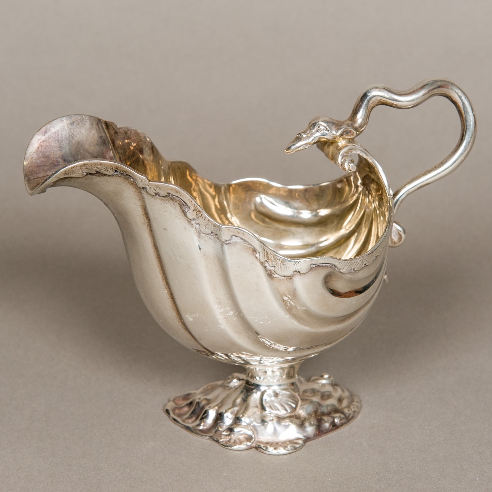 A Victorian silver sauceboat, hallmarked London 1875, maker's mark of AM Of deep scrolling form,