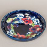 A William Moorcroft Orchid pattern fruit bowl Of shallow form, standing on a circular foot,