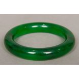 A Chinese carved spinach jade bangle 8 cm diameter.