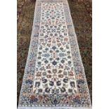 A Kashan wool runner The ivory field enclosing arabesque vines within floral border. 313 x 102 cm.