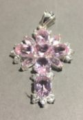 A silver and pink stone cross pendant