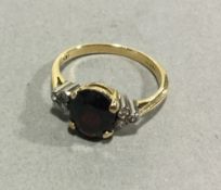 An 18 ct yellow gold diamond and oval garnet set ring