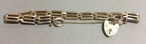 A 9 ct gold gate bracelet with heart padlock (9.