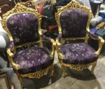 A pair of gilt framed open armchairs