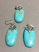 A silver and turquoise earrings and pendant set