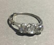 A white gold or platinum three stone diamond ring