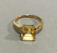 A 9 ct yellow gold ring set with an emerald cut citrine