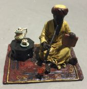 A cold painted bronze figure of an Arab smoking