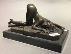 An erotic bronze figure of a reclining nude