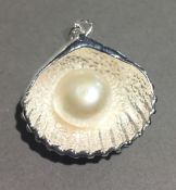 A silver shell and pearl pendant