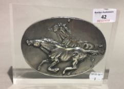 A silver plaque decorated with horses