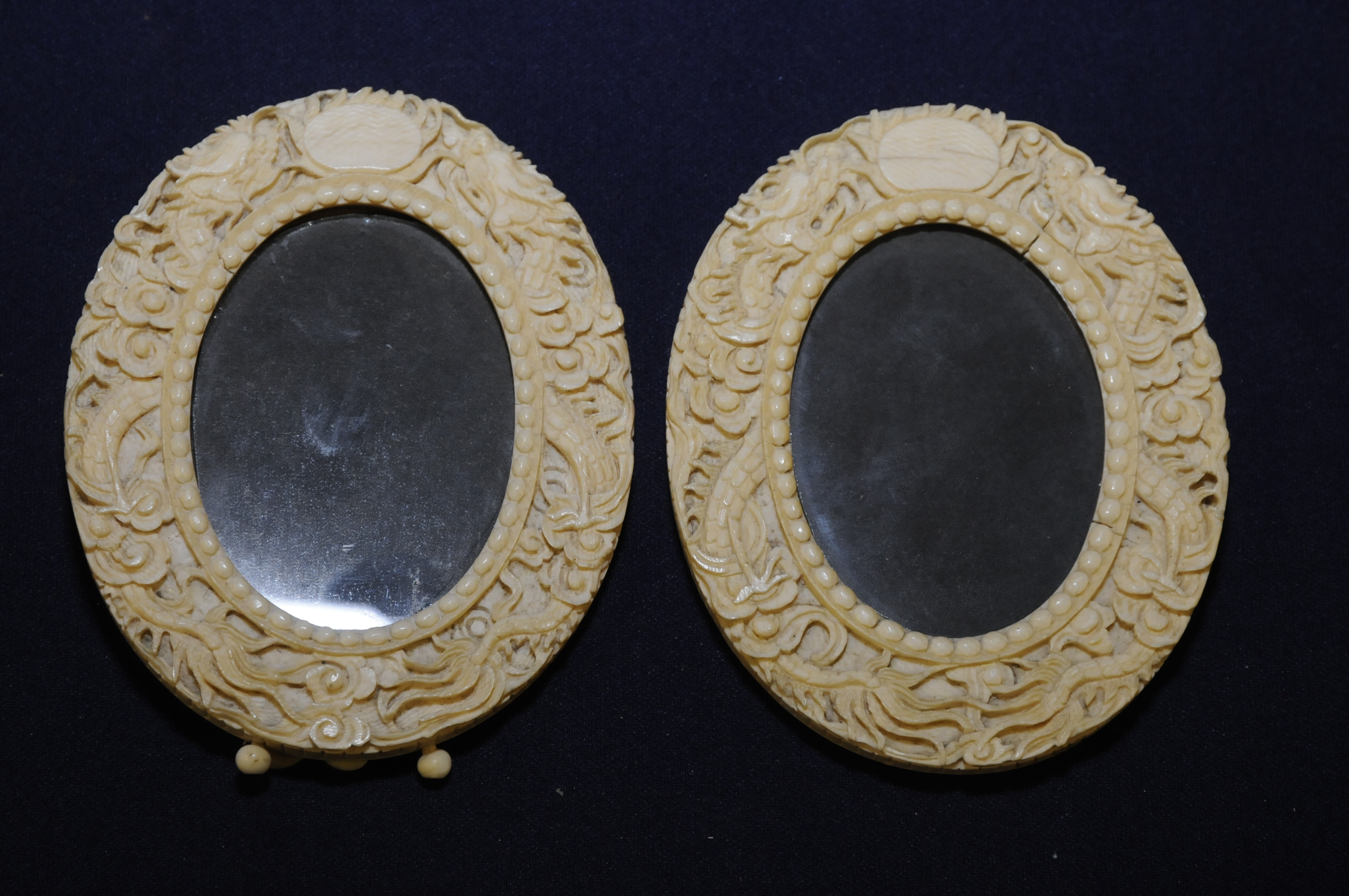 Pair of 19th C carved oriental circular picture frames, the border stylised with dragons,