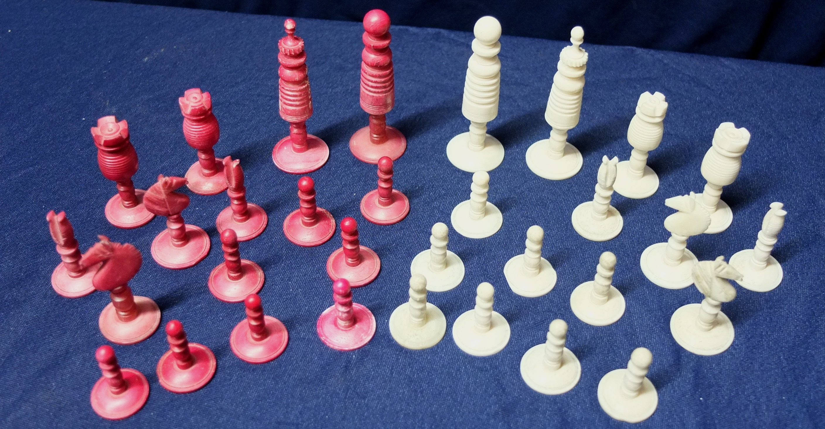 Early 20th C red stained and white carved ivory chess set (maximum height 7.