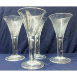 Set of four oversized glasses with large flared rims and central column stem on circular bases with