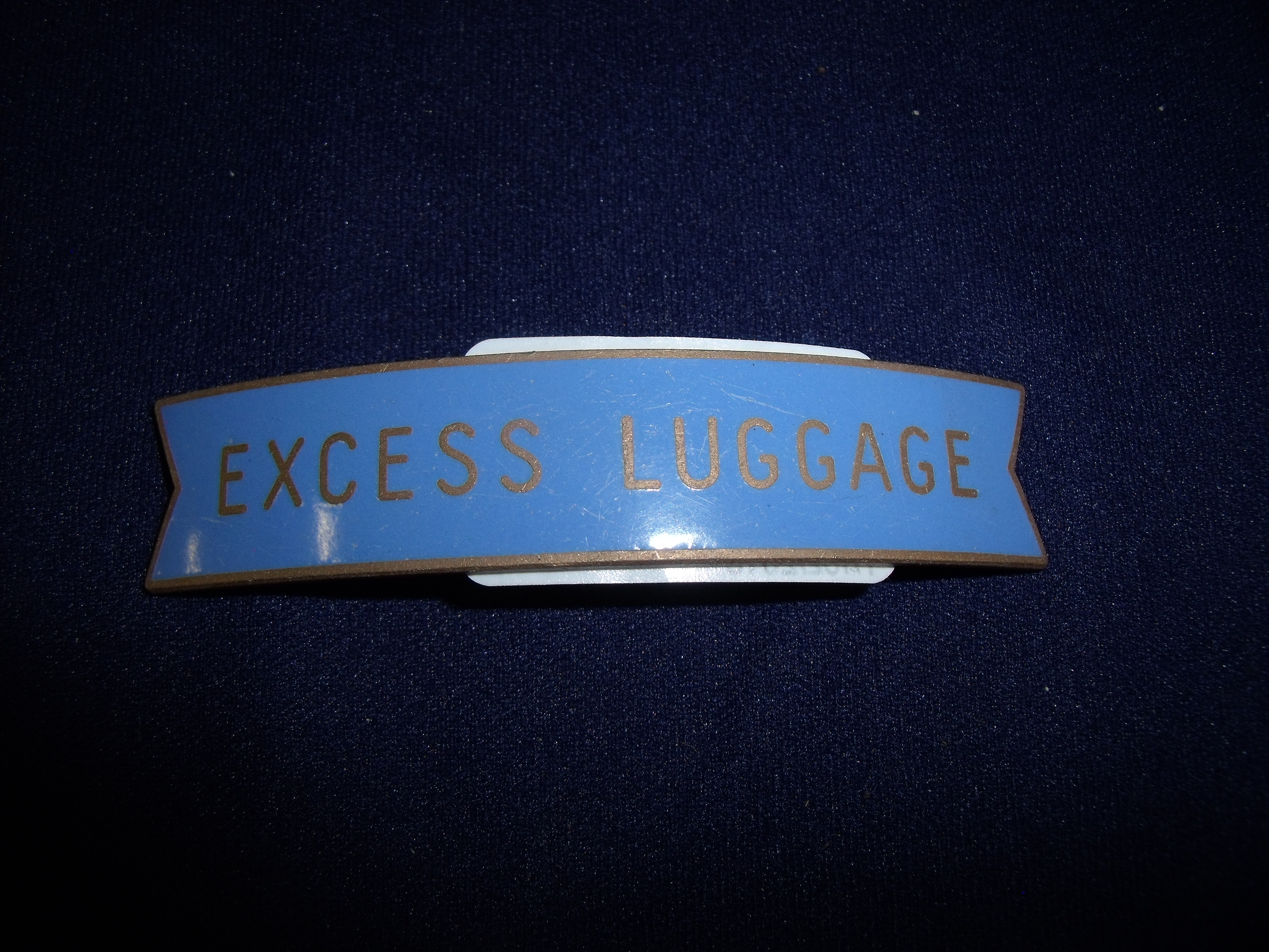 Scottish region brass and enamel small fishtail "Excess Luggage" cap badge by JR Gaunt London