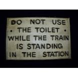 Cast metal rectangular railway notice plaque "Do not use the toilet while the train is standing in