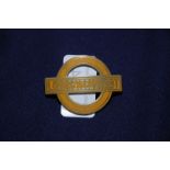 Orange enamel London Transport cap badge by J.