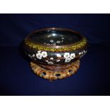 Oriental cloisonne ware bowl decorated with cherry blossoms mounted on turned wood and carved stand