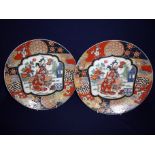 Pair of Japanese Imari style plates with central panels of seated ladies and signature panel to the