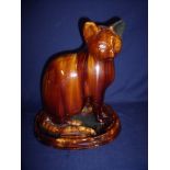 18th/19th C treacle glaze pottery figure of a seated cat on stepped oval base (height 30cm)